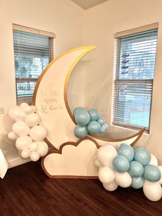 balloons are floating in the air near a crescent moon and clouds on a wooden floor