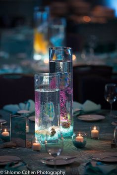 the table is set with candles, plates and glasses