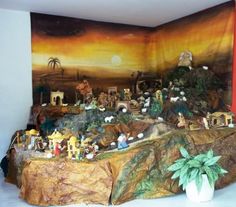 a scene with figurines on a table in front of a wall hanging from the ceiling