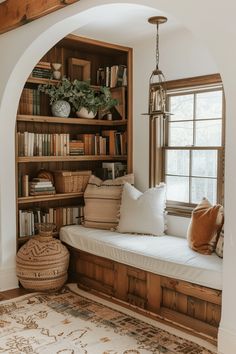 a window seat in the corner of a room with bookshelves and pillows on it