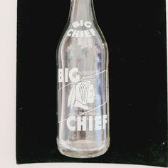 a glass bottle that is sitting on a black surface with the words big whit schiler printed on it