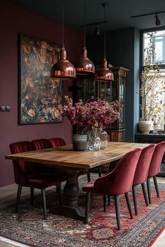 a dining room with purple walls and red chairs