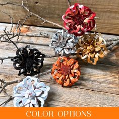 four different colored flowers sitting on top of a wooden table with text overlay that reads, color options for paper flowers