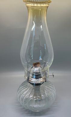 a clear glass vase with a gold top on a silver base and bottom is turned upside down