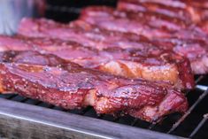 several pieces of meat cooking on a grill