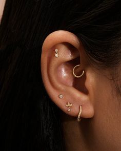 a woman's ear with three different piercings