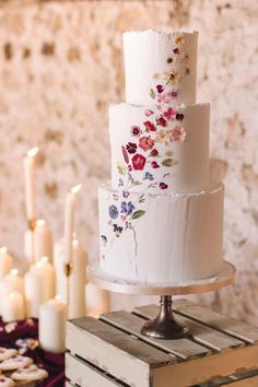 a three tiered white cake with flowers on it