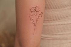 a small flower tattoo on the arm