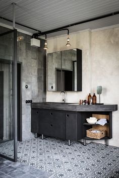 a bathroom with a sink, mirror and shower stall in the middle of the room