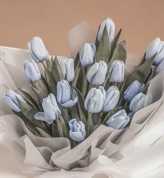 a bouquet of blue tulips sitting on top of a white cloth