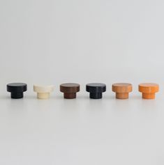 an assortment of knobs in various colors and sizes on a white surface, including black, brown, orange, and green