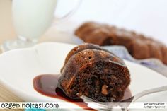 a piece of chocolate cake sitting on top of a white plate next to a glass of milk