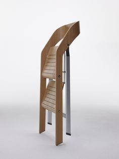 a wooden chair that is next to a metal pole