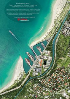 an aerial view of a city and the ocean with boats docked in front of it