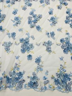 blue flowers on white sheer fabric with yellow and blue trim around the edges, as well as an applique