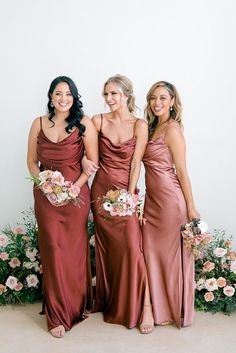 three bridesmaids pose for a photo with their bouquets