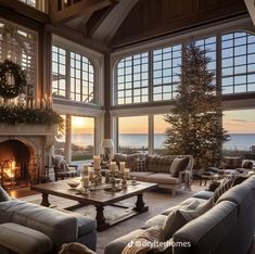 a living room filled with furniture and a fire place in front of a window overlooking the ocean