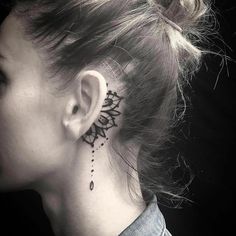 a woman with a tattoo on her neck and behind the ear is a sunflower