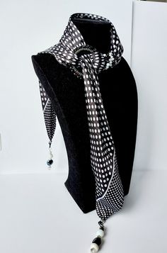 Black ring scarf with white polka dots embellished with pearls and hard stones in the colors of the scarf. Materials 100% viscose scarf Fancy hard stones Embroidered crochet ring This scarf, like all ring scarves in the KINY collection, is worn in three different ways: classic poses for everyday life, tie poses to give a touch of originality and elegant poses for parties. More than just a scarf, this jewel scarf will give your everyday outfits an original touch. It's also the perfect accessory t Handmade Elegant Scarves One Size, Scarf And Pearls, Rhinestone Scarf, Polka Dot Scarf Outfit Black And White, Black Chic Scarves One Size, Crochet Rings, Polka Dot Scarf, White Polka Dot, Original Gift