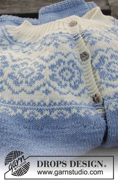 a blue and white sweater sitting on top of a wooden table