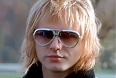 a man with blonde hair and sunglasses looking at the camera