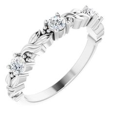 a white gold ring with three diamonds on the side and an intricate design in the middle