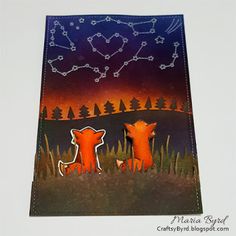 a card with two foxes sitting on the grass in front of a sky filled with stars