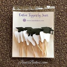 four toothpicks with black and white leaves on them are in a plastic package