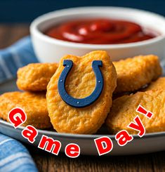 the game day appetizers are served on a plate with a bowl of ketchup