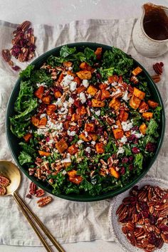 a salad with pecans, cranberries and feta cheese in a green bowl