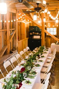 a long table is set up with white chairs and place settings for the dinner guests