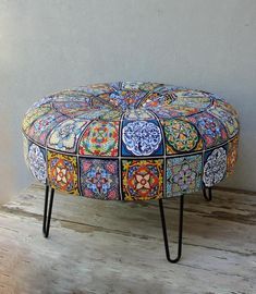 a colorful ottoman sitting on top of a wooden floor