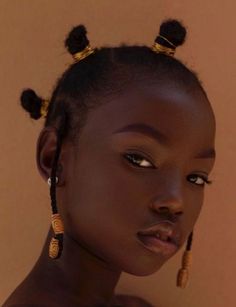 a woman with large earrings on her head and an afro hairstyle is looking at the camera