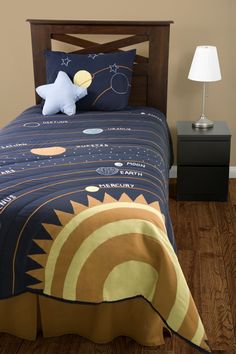 a bed in a room with a wooden headboard and night sky bedspread