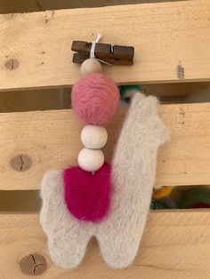 a close up of a stuffed animal hanging on a wooden wall with other toys in the background