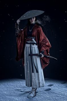 a woman in a kimono holding an umbrella and walking through the snow at night