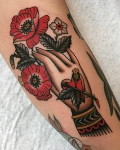 a woman's arm with tattoos and flowers on it