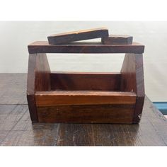 a wooden box sitting on top of a wooden table next to a blue object in the background