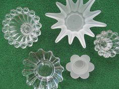 four clear glass dishes on green carpeted surface