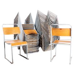 a group of chairs sitting next to each other in front of a white wall with multiple pieces of furniture stacked on top of it