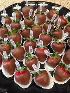 chocolate covered strawberries are arranged in the shape of heart - shaped hearts on a black plate