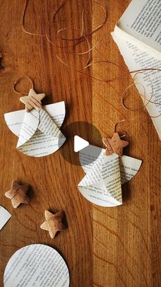 some paper stars are sitting on top of an open book and two other pieces of paper sit next to each other