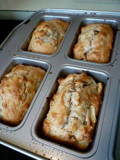 four muffins in a pan on top of an oven