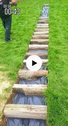 a man standing in the grass next to a wooden structure with water coming out of it