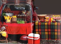 a red truck parked next to a picnic table filled with food and drink bottles on it's side