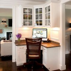 a desk with a computer on top of it next to a chair in a room