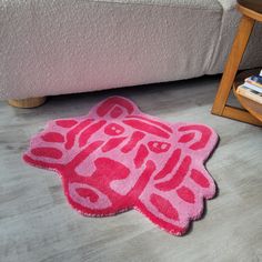 a pink rug on the floor next to a chair