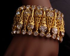 "This is gorgeous brilliant rhinestone really wide and fabulous bracelet.Even brighter and more brilliant in person this wide ( 1 3/4\") has columns of beautiful golden filigree and hand set prong set rhinestones .This gorgeous bracelet will not disappoint you, it will be the envy of everyone who sees it. This is in great condition with not wear to the gold plate. . This is heavy and well made and I hope it gets a home where it will be shown off and adored.. See photos for all the dimensions. ga Filigree Bracelet, Spring Hill, Jewelry Bridal, Bridal Bracelet, Bracelet Vintage, Gorgeous Bracelet, Rhinestone Bracelet, Prong Setting, Bridal Jewelry