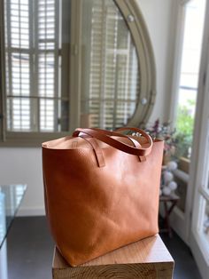 "Oversized camel leather bag, made with the highest quality veg tanned leather. Its clean design and its 7 inches depth makes this beautiful bag a versatile bag to carry many things. Features: - Highest quality Full Grain Veg Tanned leather - Aprox Size: 14 in wide at the bottom, at the top, the width depends on how full is the bag, but it should be around 15-17 inches (36 cm at bottom - wider at the top - maybe 40-42 cm) - easily fits a 15\" laptop 13 in high (33 cm) 7 inches deep (18 cm) - 3 b Cognac Smooth Grain Bucket Bag For Everyday, Dark Tan Rectangular Satchel For Daily Use, Everyday Brown Shoulder Bag With Double Handle, Everyday Brown Double Handle Shoulder Bag, On-the-go Smooth Grain Tote Bucket Bag, Rectangular Dark Tan Shoulder Bag For Everyday, Dark Tan Rectangular Shoulder Bag For Everyday, Caramel Shoulder Bag For Everyday Use, Caramel Shoulder Bag With Removable Pouch For Everyday