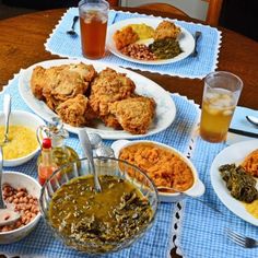 a table topped with plates of food next to cups and sauces on top of a blue cloth